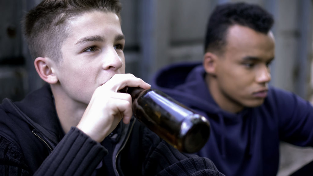 Problem teenagers secretly drinking beer, skipping school classes, hooligans